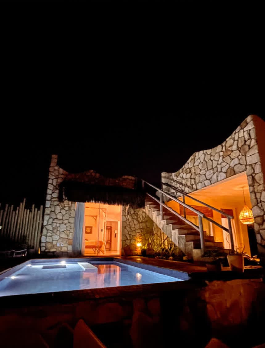 Kilombo Villas - Das Rosas - Casa de estilo tropical com varanda, jardim bem cuidado e detalhes em palha e madeira, ideal para férias ou moradia na praia.