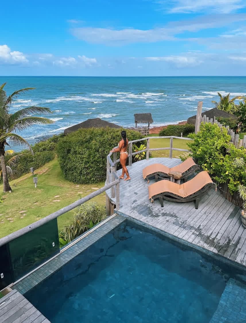 Kilombo Villas - Das Rosas - Belleza tropical na praia com piscina de borda infinita, lounge ao ar livre, vegetação exuberante e vista deslumbrante do oceano sob céu azul claro.