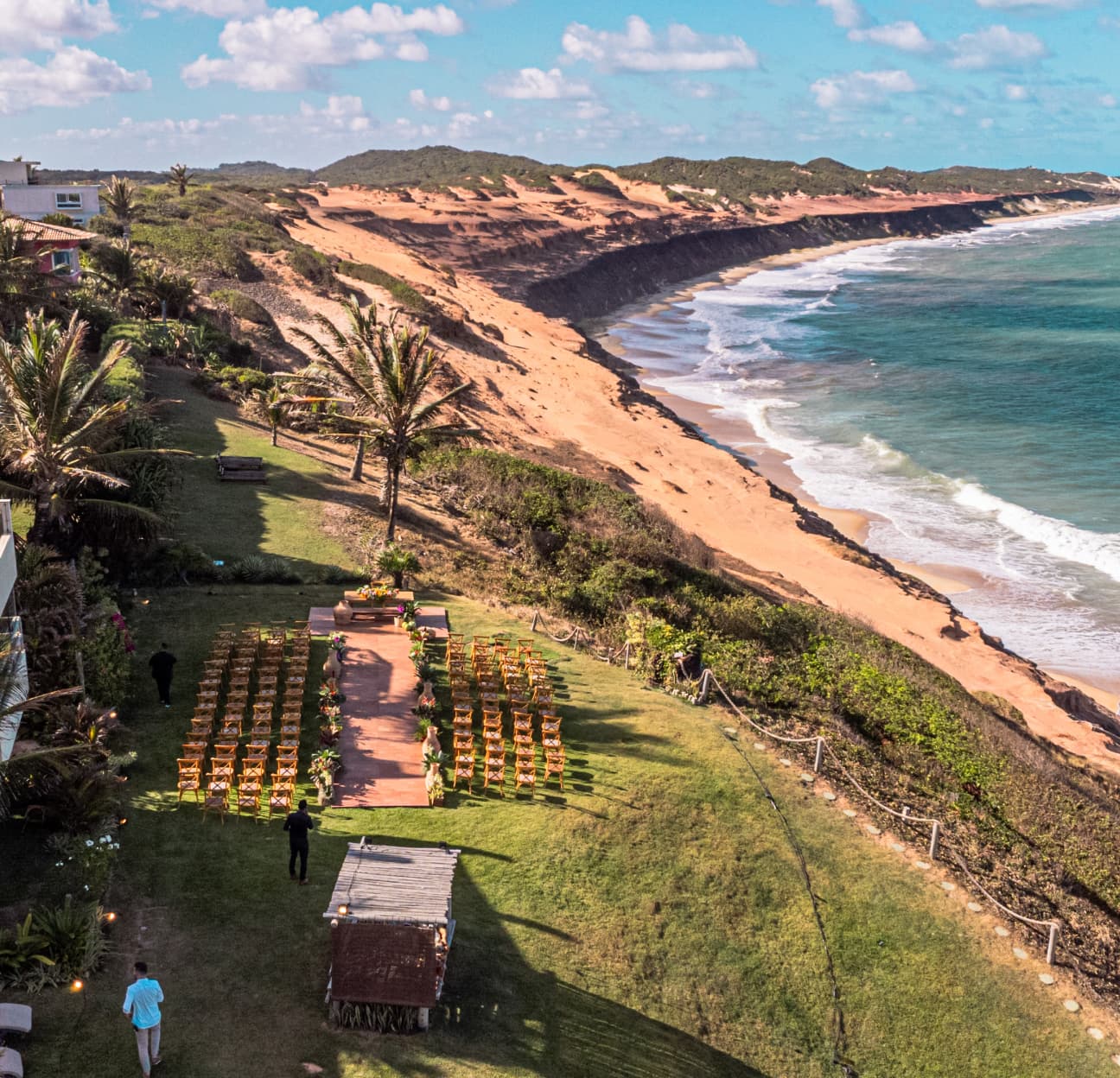 Vista aérea da cerimônia de casamento montada no gramado à beira da falésia com praia de Sibaúma ao fundo