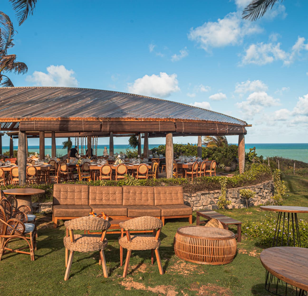 Terraço do Kibo Restaurante com mobília rústica e vista panorâmica para o oceano, preparado para evento de casamento