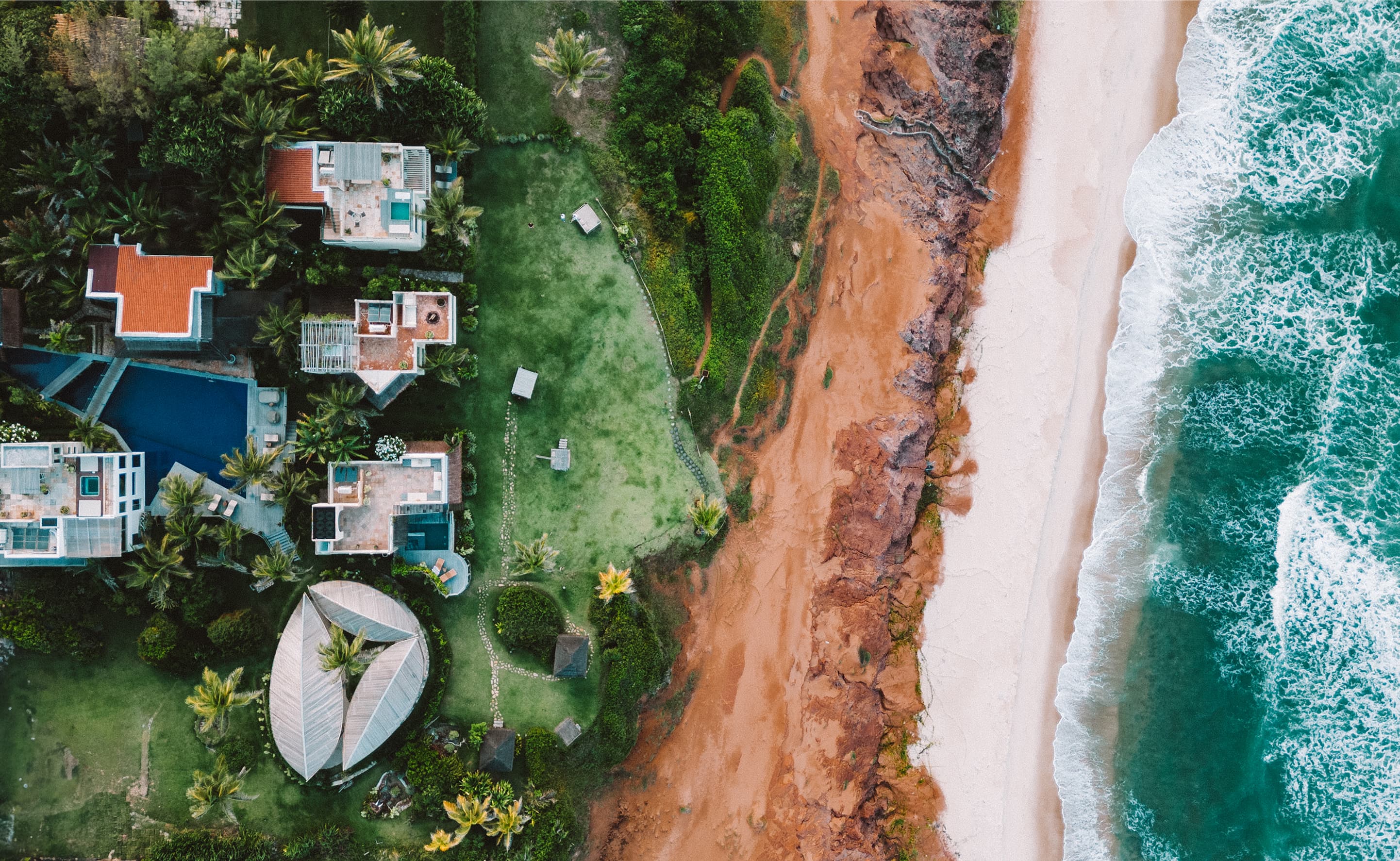 Vista aérea do Kilombo Villas com villas, piscinas e jardins sobre as falésias de Sibaúma, Tibaú do Sul