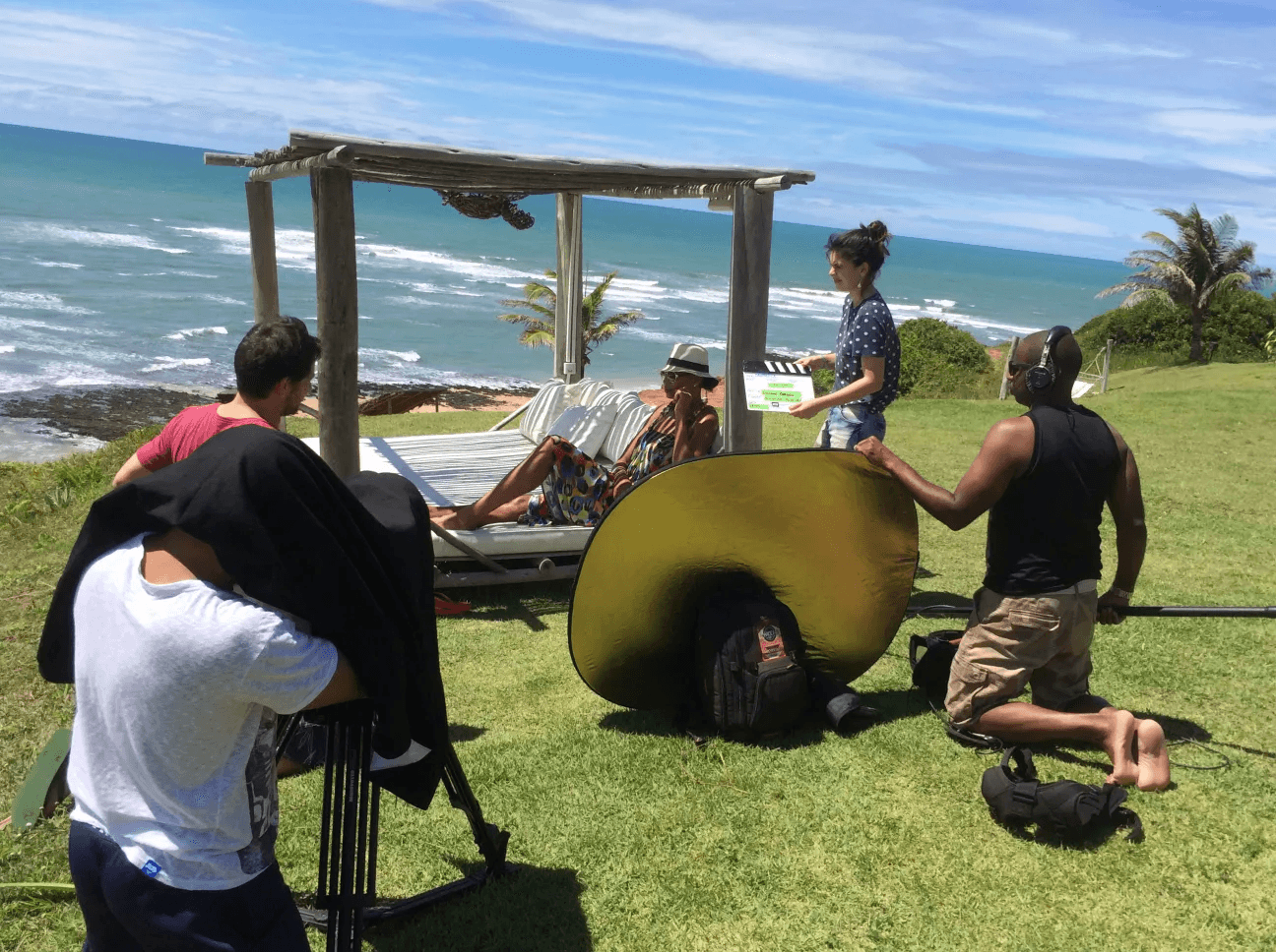 Equipe de filmagem em produção audiovisual ao ar livre com vista para o mar no Kilombo Villas, Sibaúma