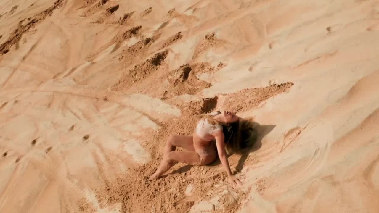Vista aérea de hóspede reclinada nas dunas de areia da praia de Sibaúma em pose de conexão com a natureza