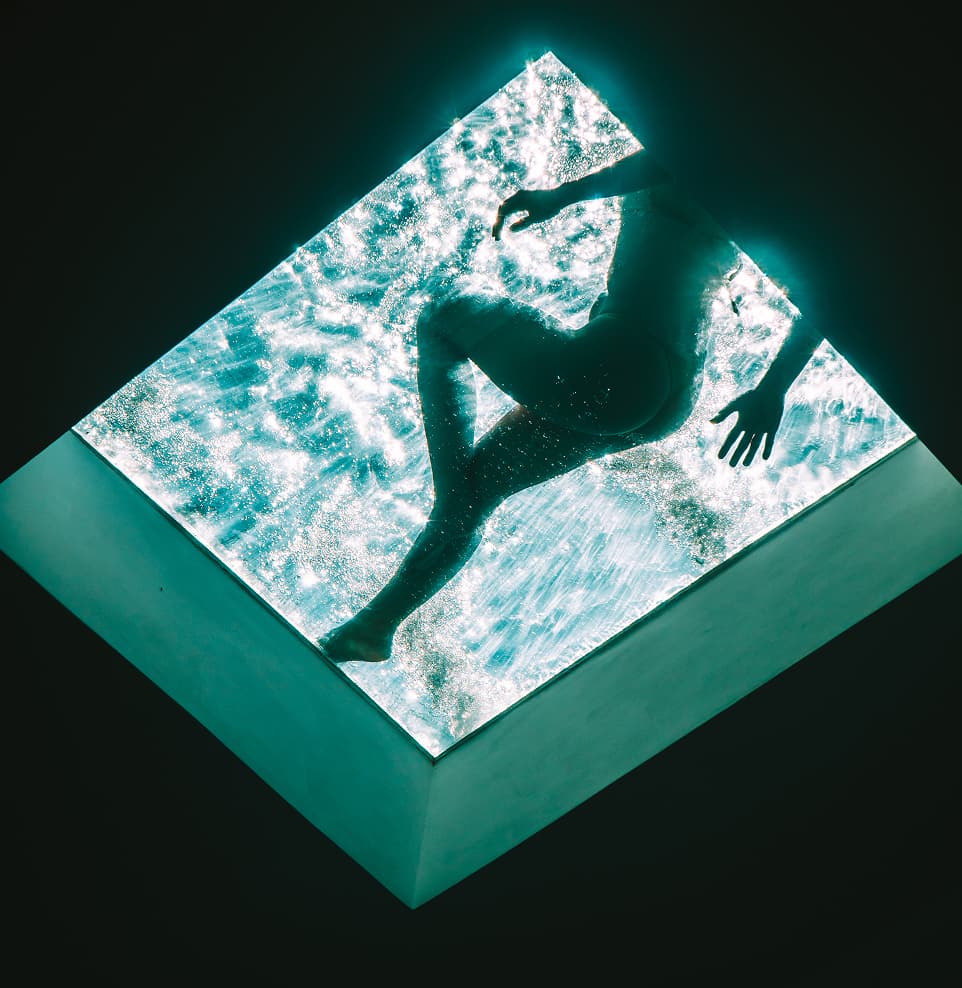 Vista aérea de hóspede nadando na piscina iluminada do Kilombo Villas