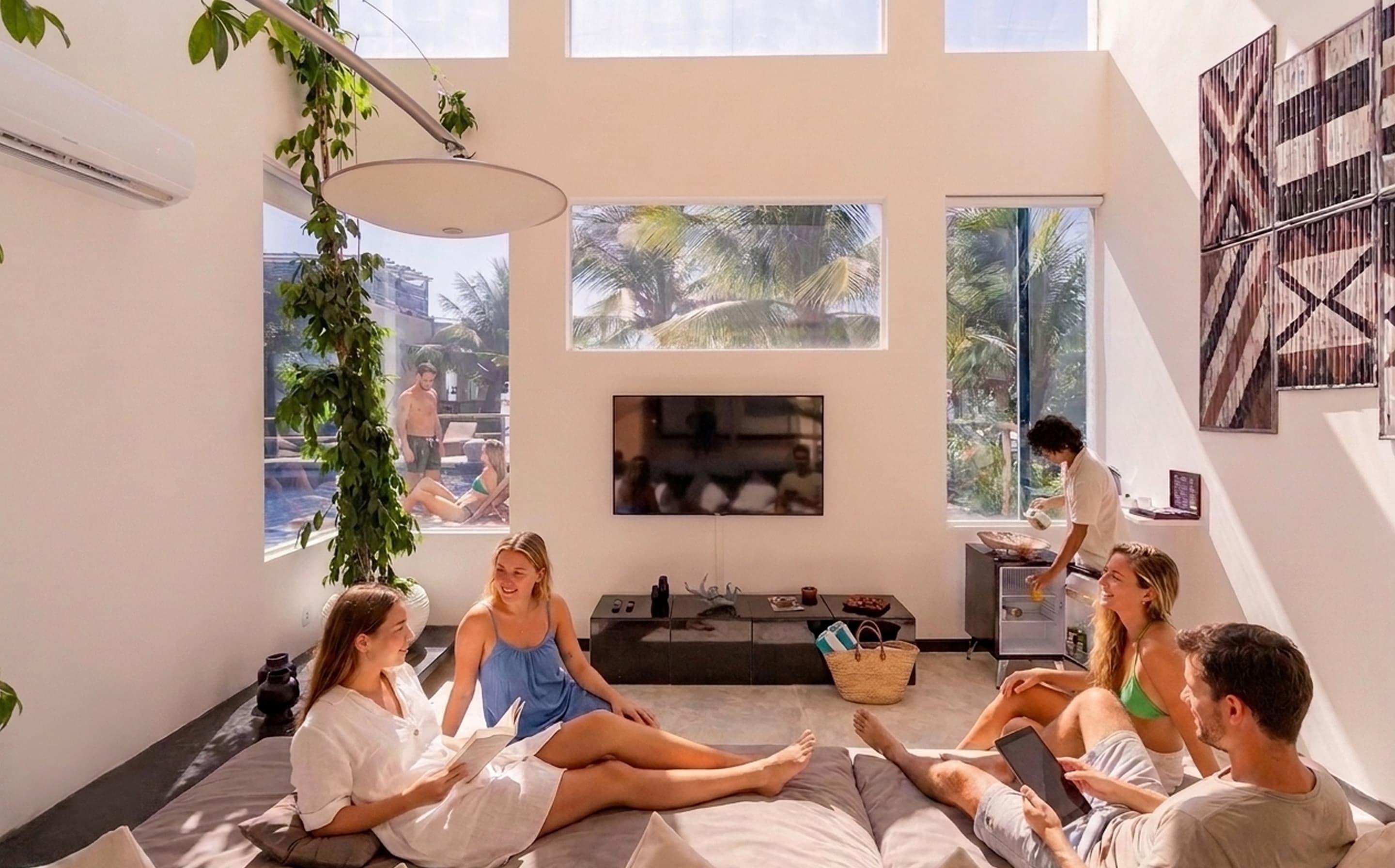 Grupo de hóspedes relaxando na sala luminosa de uma villa do Kilombo Villas com serviço de mordomo
