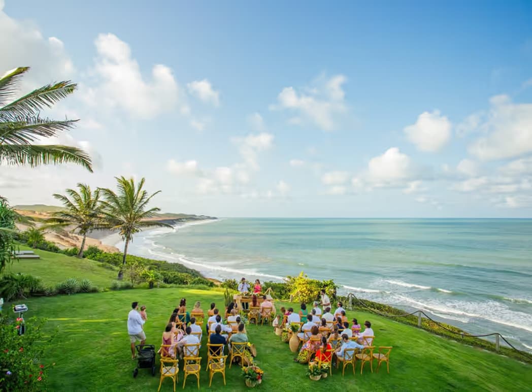 Cerimônia de casamento ao ar livre no gramado com vista para o mar no Kilombo Villas