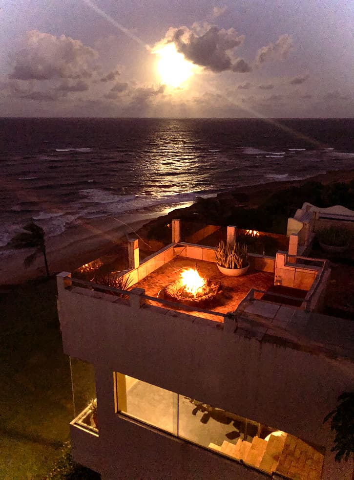 Fogueira acesa no terraço de uma villa com vista para o mar sob a luz da lua no Kilombo Villas