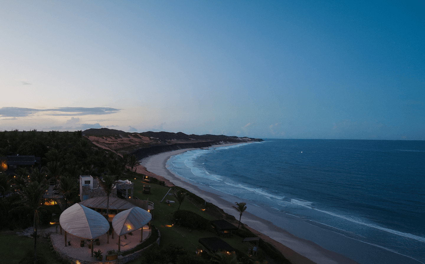 Vista panorâmica da costa de Sibaúma ao entardecer com o Kilombo Villas, falésias e oceano