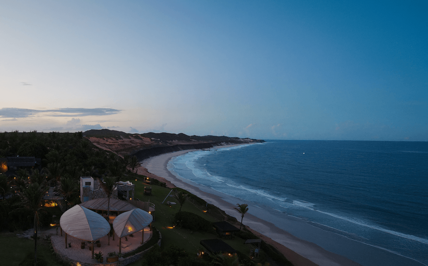 Vista panorâmica da costa de Sibaúma ao entardecer com o Kilombo Villas, falésias e oceano
