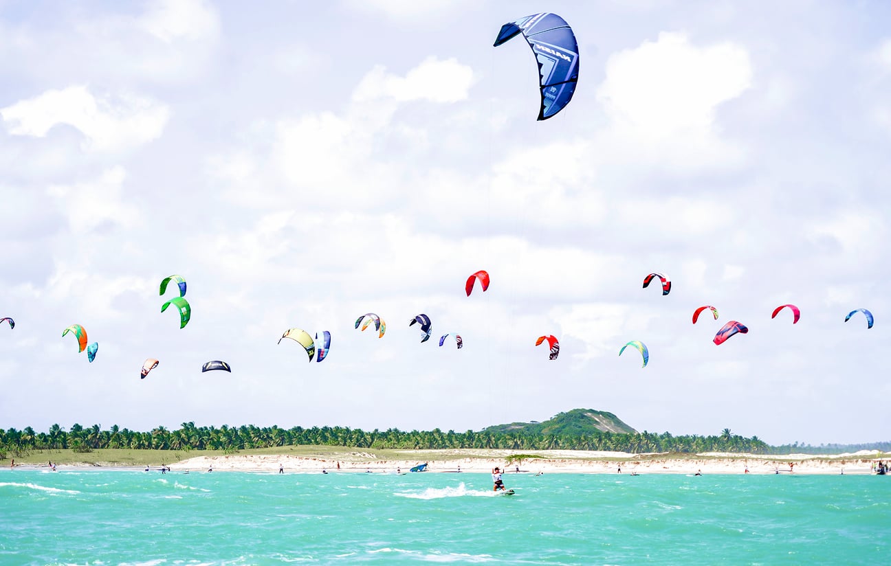 Aerial view of colorful kites flying over the beach near Kilombo Villas on a sunny day
