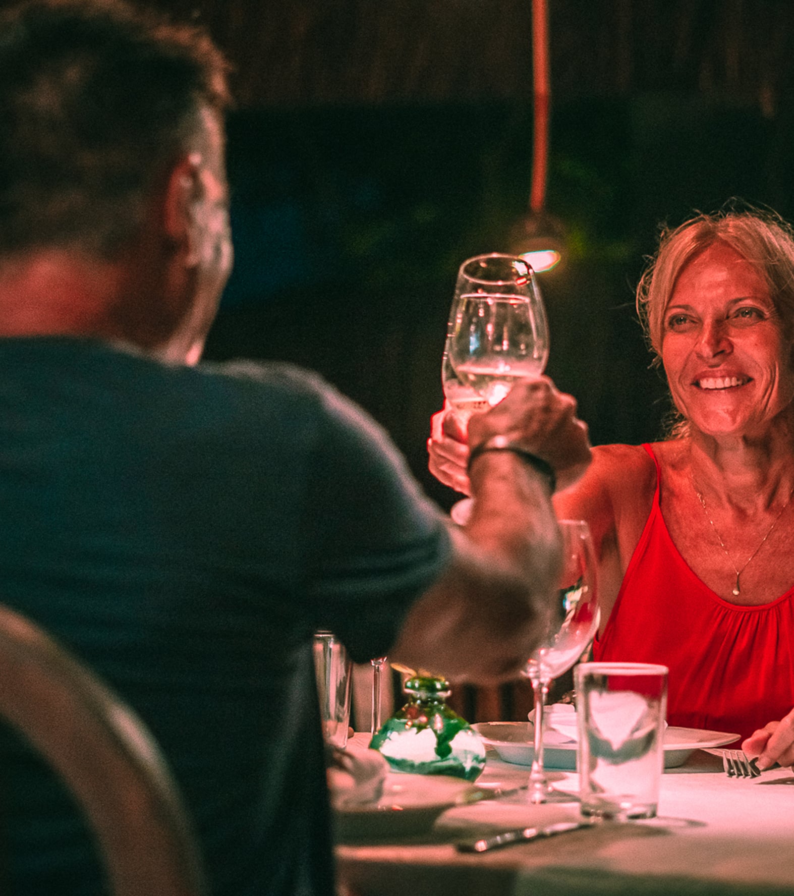 Couple toasting with wine glasses at a romantic dinner at Kibo Restaurant in Kilombo Villas
