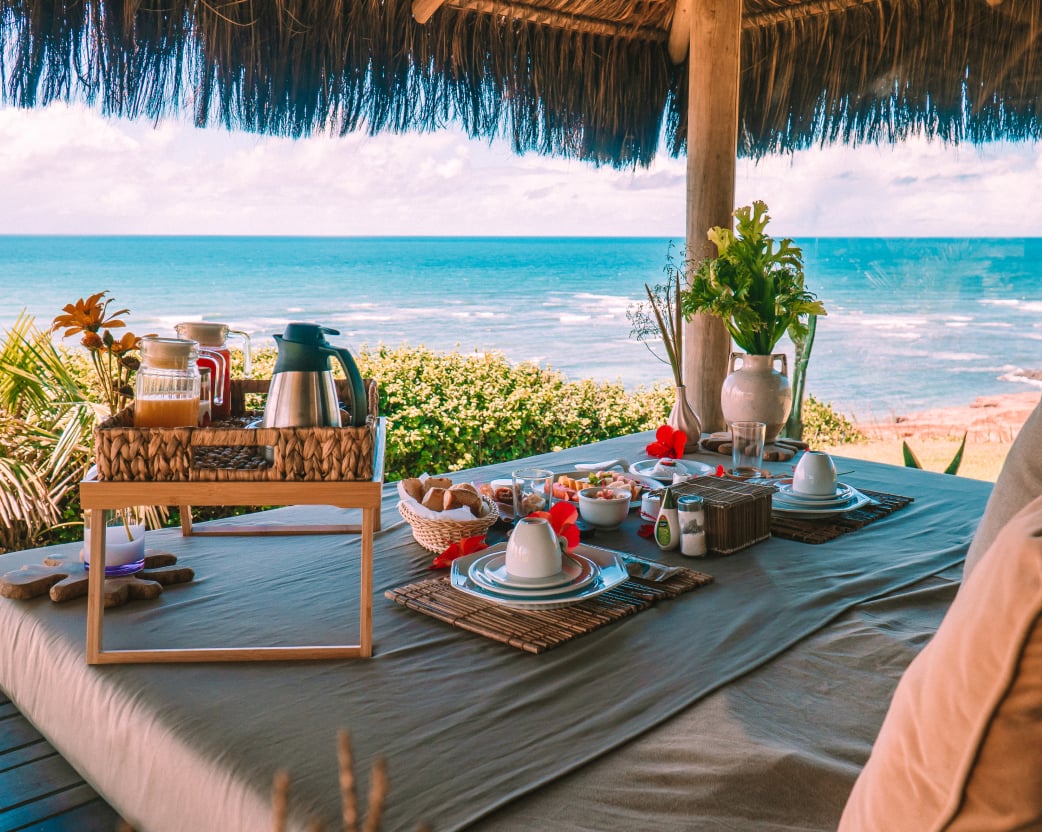 Outdoor breakfast table in the Kilombo Villas bungalow overlooking the ocean of Sibaúma