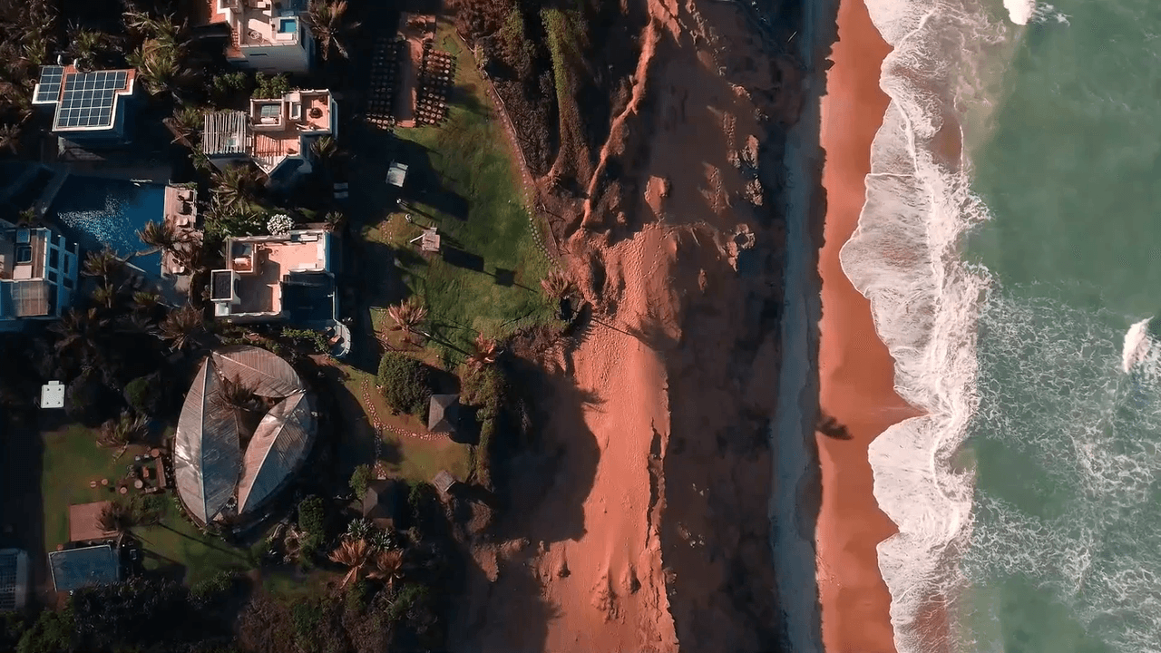 Vista aérea do Kilombo Villas com villas, jardins e a praia de Sibaúma ao fundo