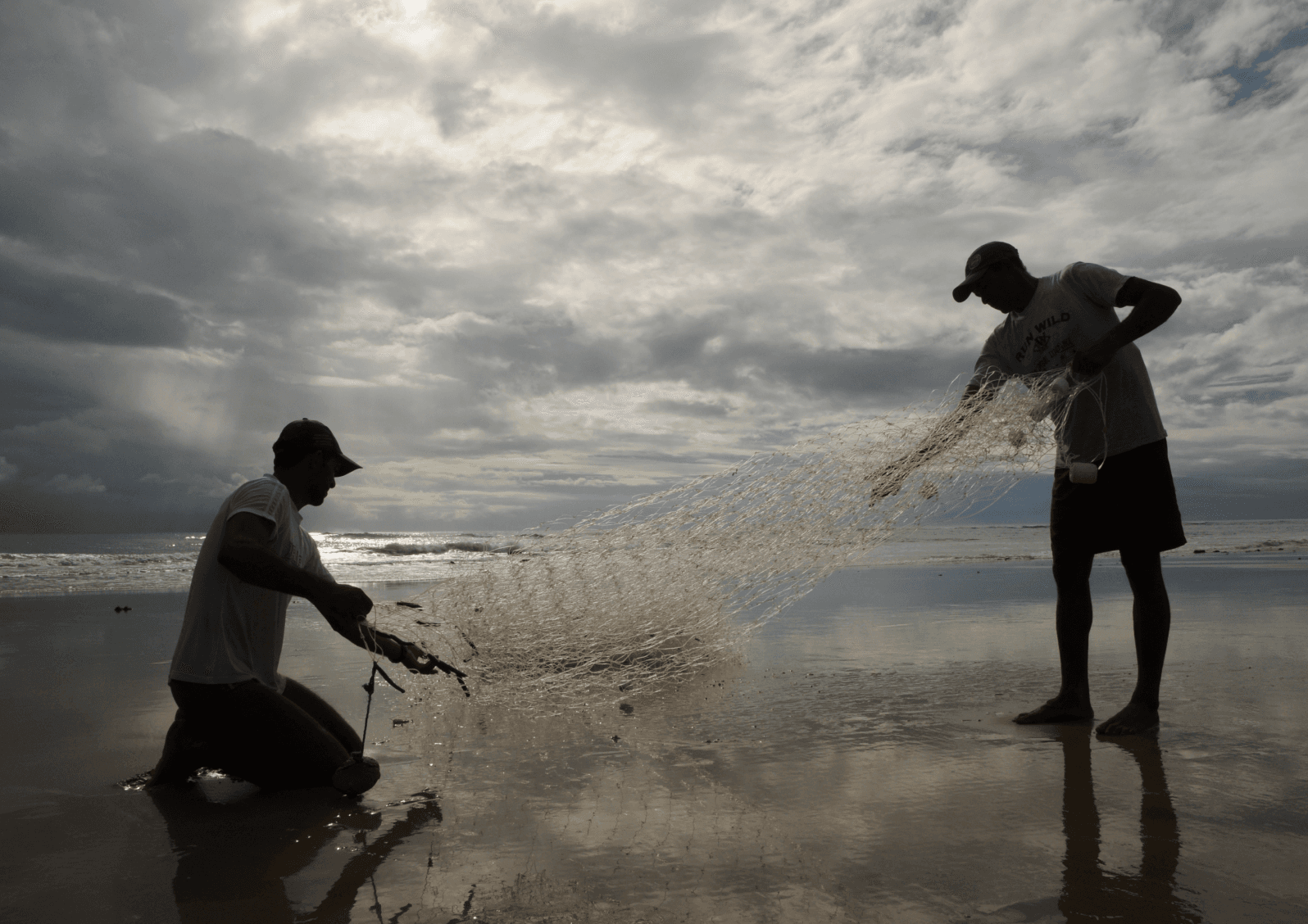 Pescadores artesanais recolhendo rede na beira-mar de Sibaúma, tradição da comunidade local