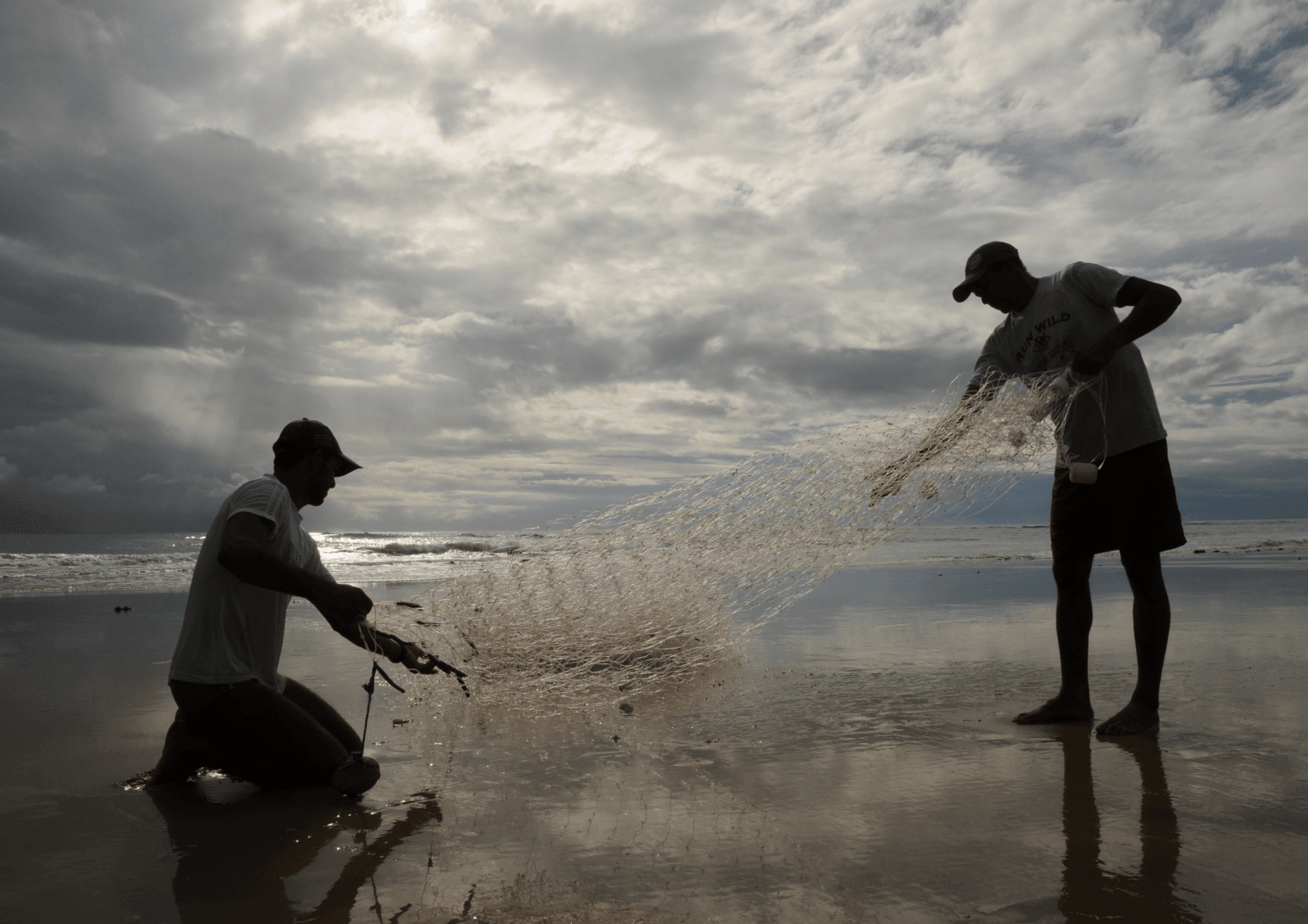 Pescadores artesanais recolhendo rede na beira-mar de Sibaúma, tradição da comunidade local