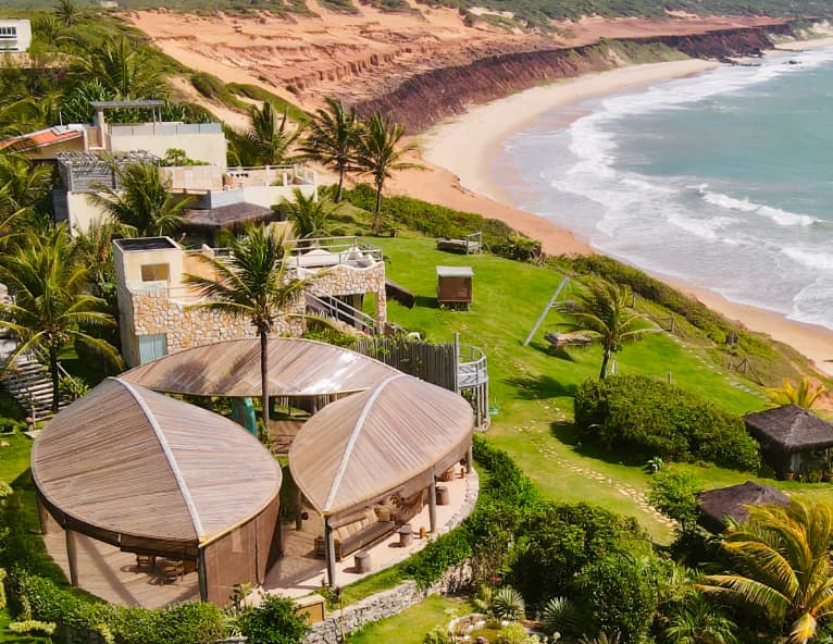 Vista aérea do Kilombo Villas com o pavilhão Kibo e a praia extensa de Sibaúma ao entardecer