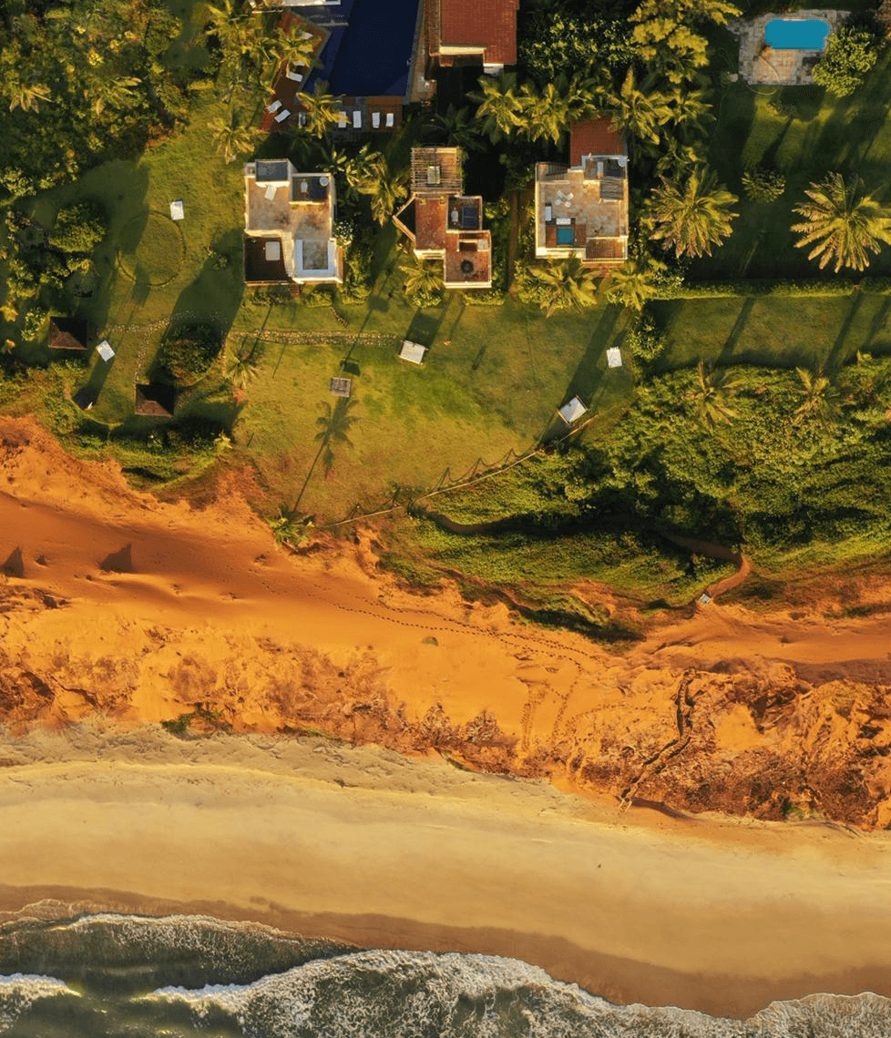 Vista aérea do Kilombo Villas mostrando as villas integradas à vegetação nativa e falésias de Sibaúma, Tibaú do Sul
