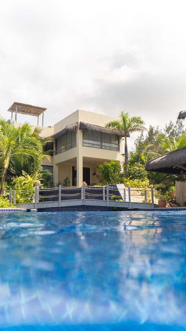 villa do Kilombo Villas vista da piscina com vegetação tropical e arquitetura moderna