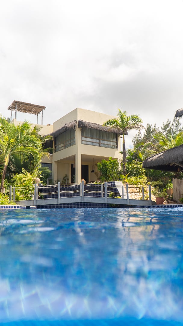 villa do Kilombo Villas vista da piscina com vegetação tropical e arquitetura moderna