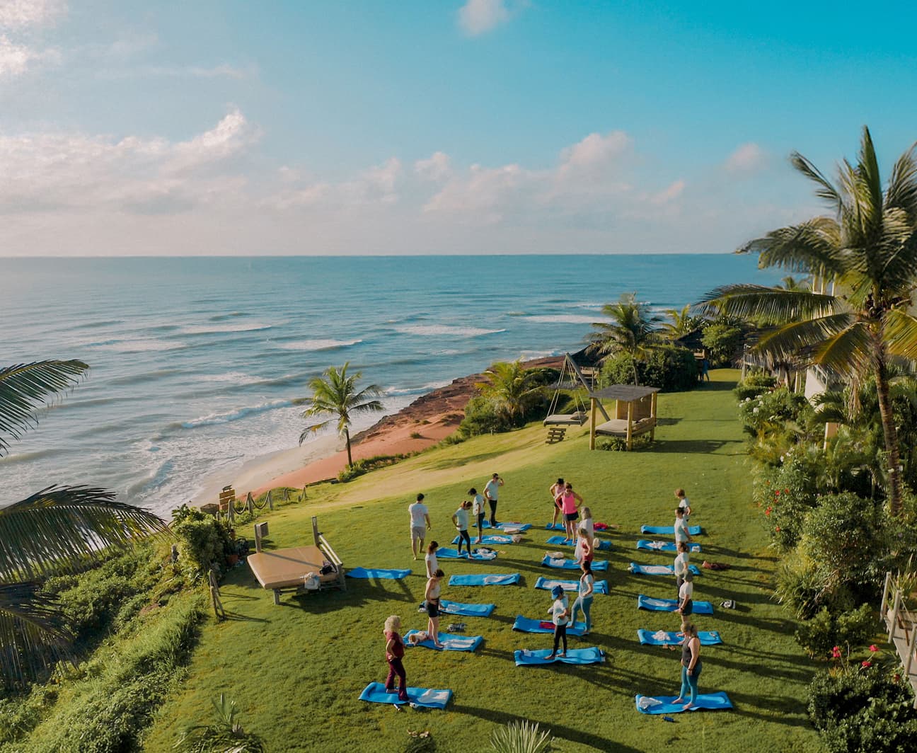 Vista aérea de aula de yoga em grupo no jardim à beira-mar do Kilombo Villas em Sibaúma