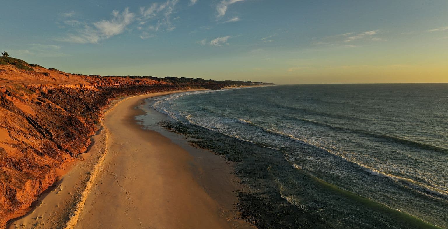 Vista aérea da falésia e da praia ao entardecer