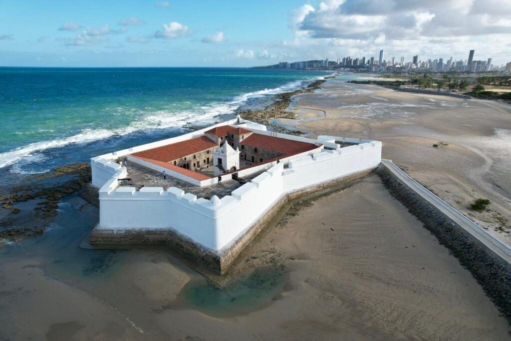 Vista aérea do Forte dos Reis Magos com skyline de Natal e litoral ao fundo