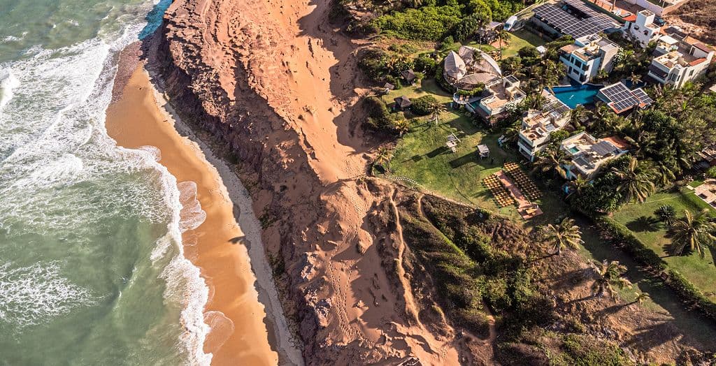 Vista aérea da falésia e da praia com as villas do Kilombo Villas ao lado, em Sibaúma