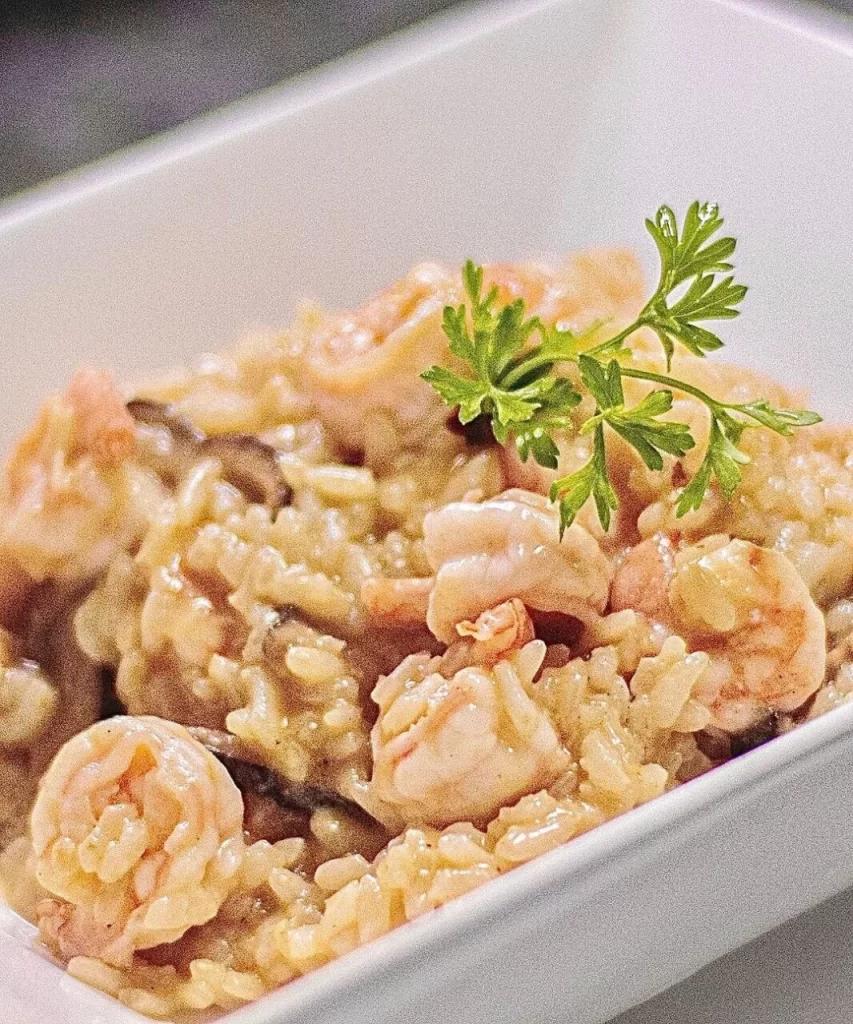 Risoto de camarão em tigela branca com salsa verde no restaurante Lampião