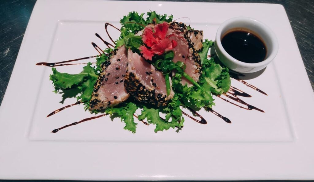 Tataki de atum encrostado em gergelim com molho de soja e hibisco decorativo