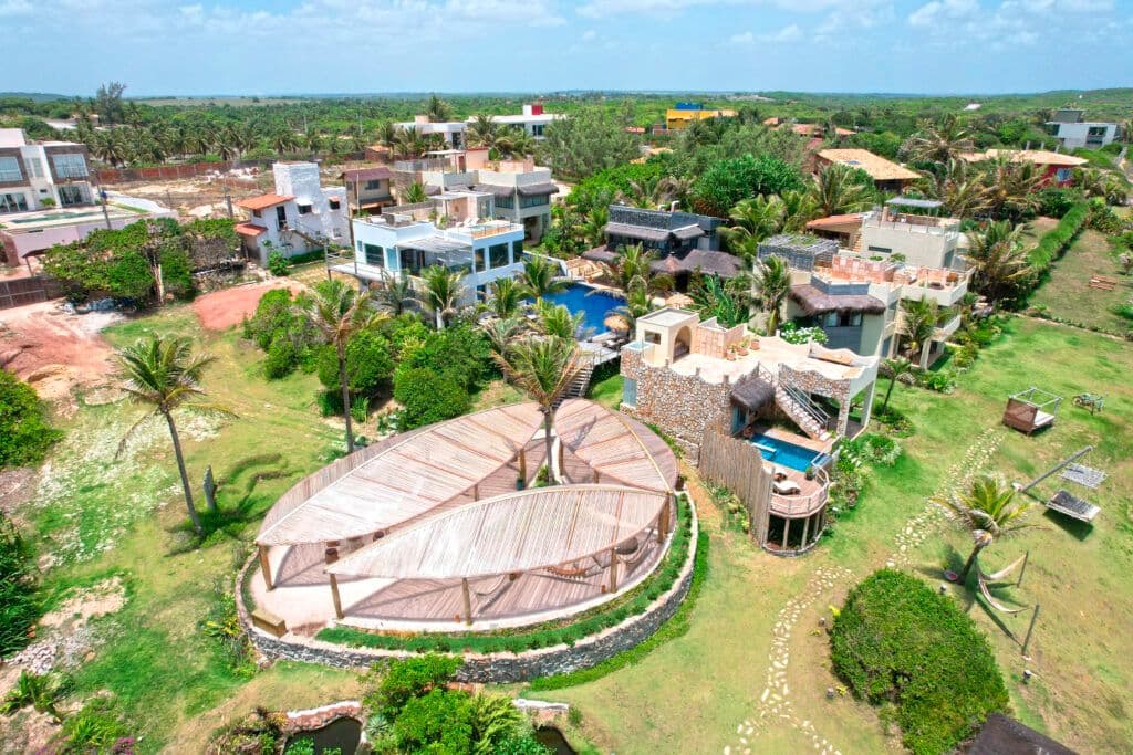 Vista aérea do condomínio Kilombo Villas com estrutura oval de madeira e jardins verdes