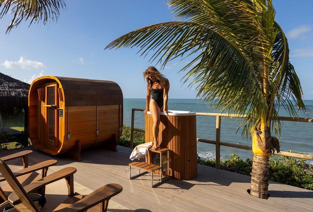 Sauna de barril e banheira de imersão em um deck de frente para o mar, no Kilombo Villas