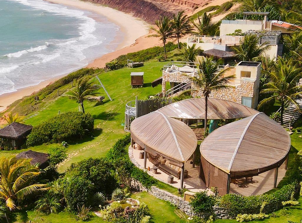 Vista aérea do Kilombo Villas com seus espaços de convivência, a praia e as falésias ao fundo